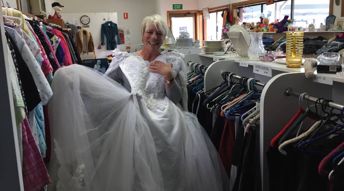 Store manager Rene Brooks with a glorious satin, tulle and pearl beaded wedding gown which is marked at $50 but can be snapped up for $25 during the half price sale at the moment.