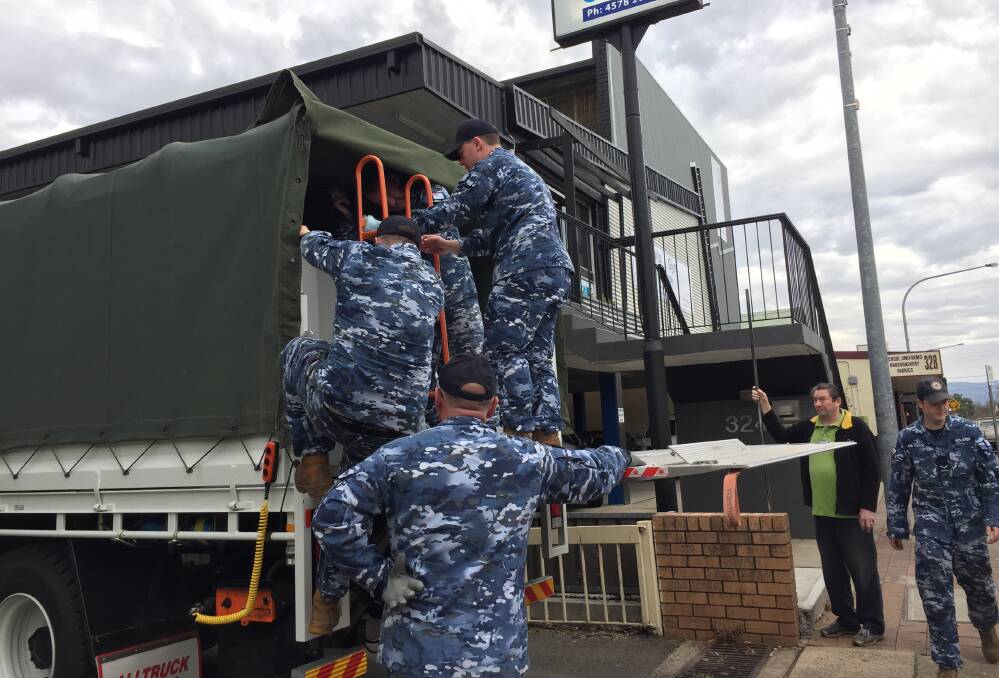 Commanding Officer of 22 Squadron Paul Reddacliff and two young squadron members unload the second truck full of furniture and clothes at the new premises under No Limits Gym on Windsor Street, Richmond, watched by Peter Hamilton of Richmond Men’s Shed.