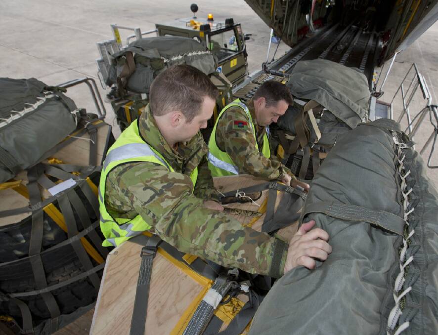 Lance Corpoal Nicholas Schepel, front and Corporal Andrew Munro secure the load in the aircraft.