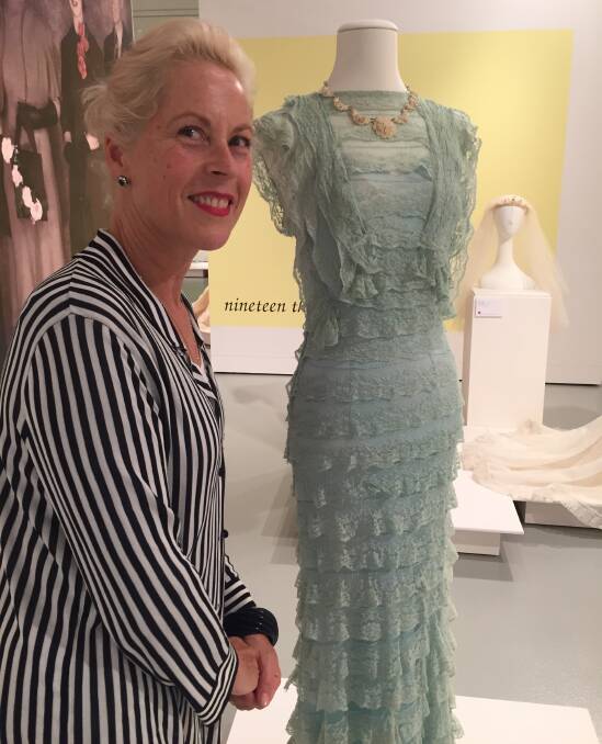 Exhibition owner Charlotte Smith with one of the most popular gowns - a tiny mint lace 1930s creation.
