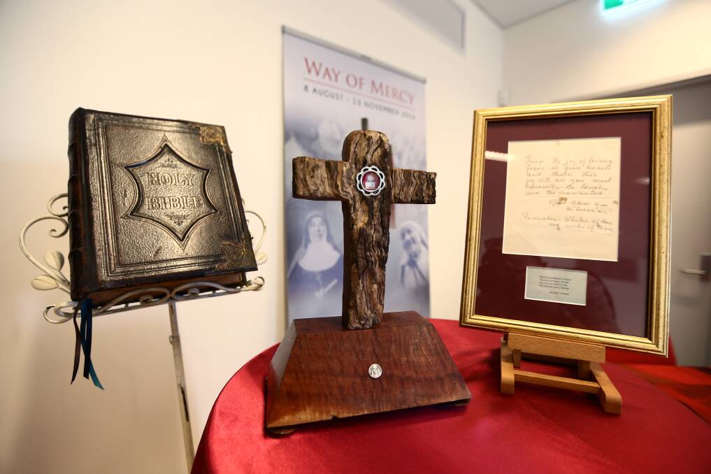 The centuries-old Bible, the hair strand of St Mary McKillop (in the wooden cross) and the letter from Mother Teresa were at the front of the ceremony at Windsor on Friday morning. Picture: Geoff Jones