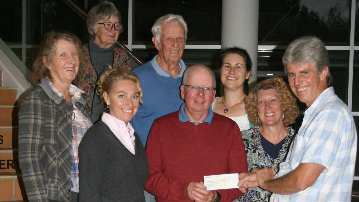 Men of the Trees NSW president Mark Anderson, right, gives the cheque to HEN members, including Danielle Wheeler.