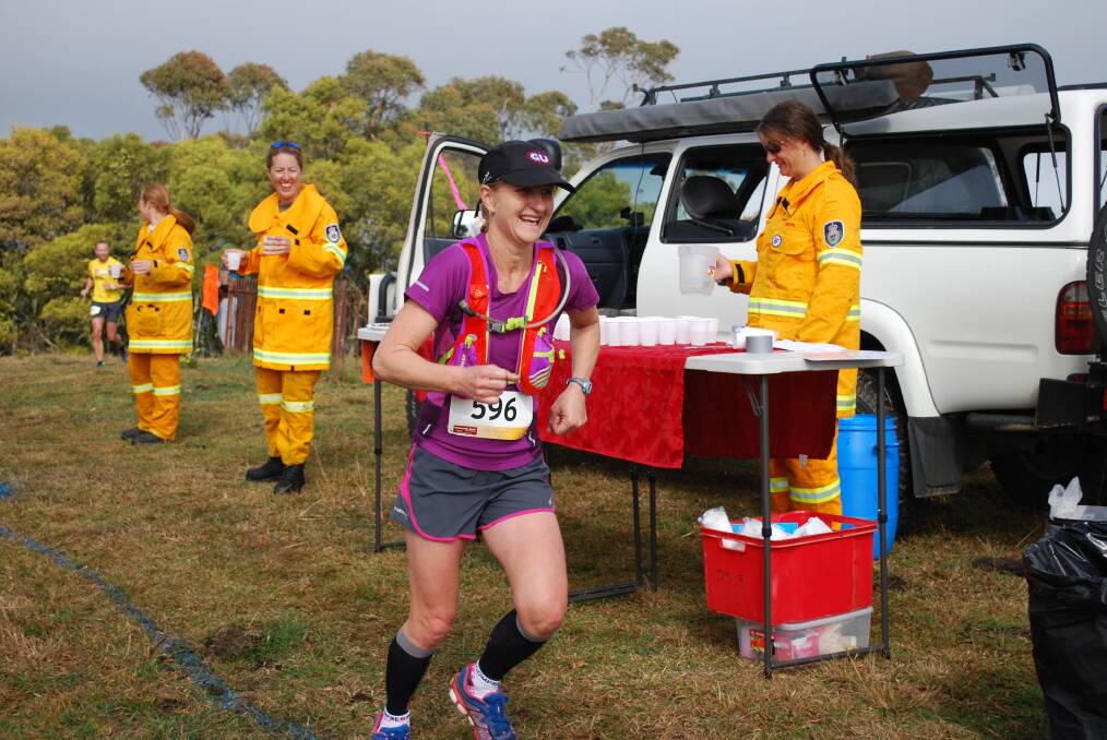 RFS volunteers dispense drinks, smiles and encouragement to runners in 2014.