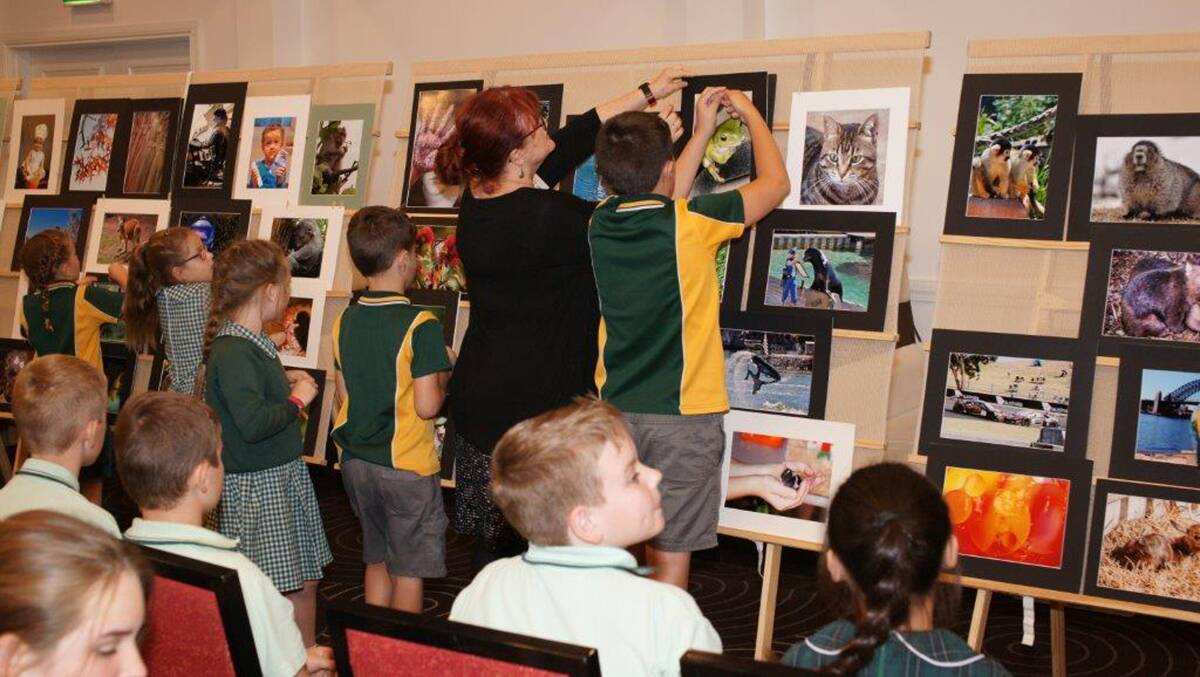 The Hawkesbury Camera Club president helps students during their selection of the best photos for the ward.