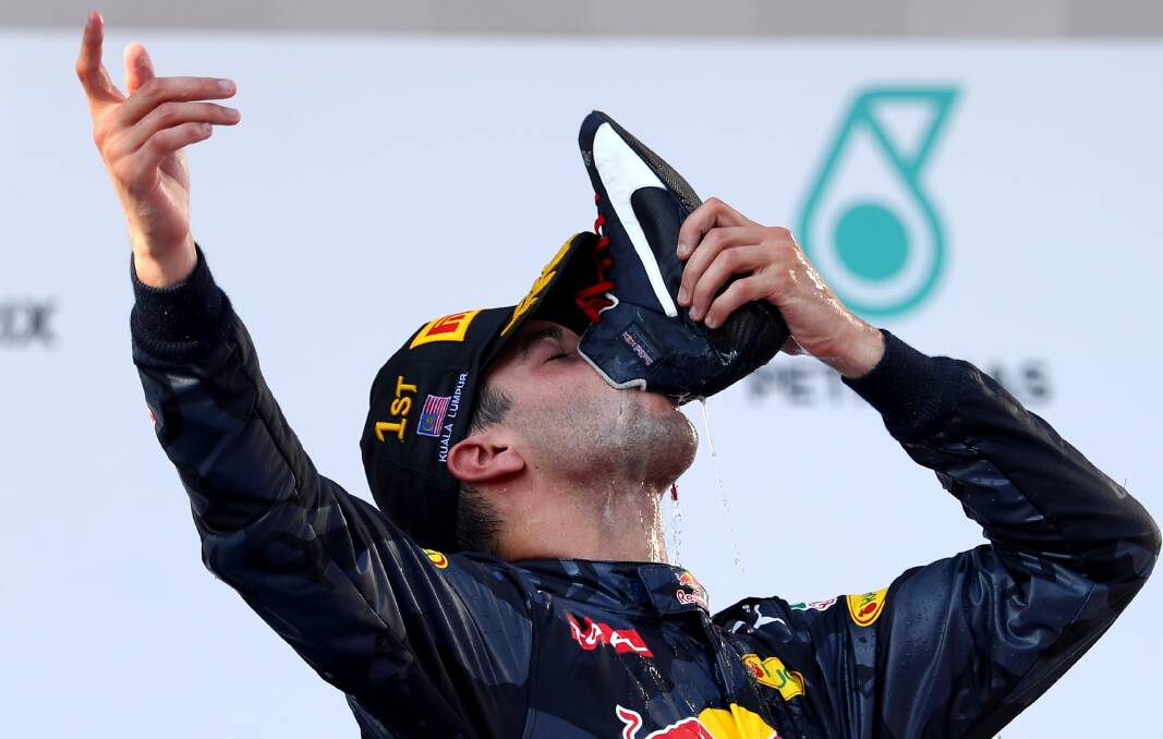 Daniel Ricciardo "does a shoey" while celebrating his win at the 2016 Malaysian F1 grand prix. Photo: Getty Images.