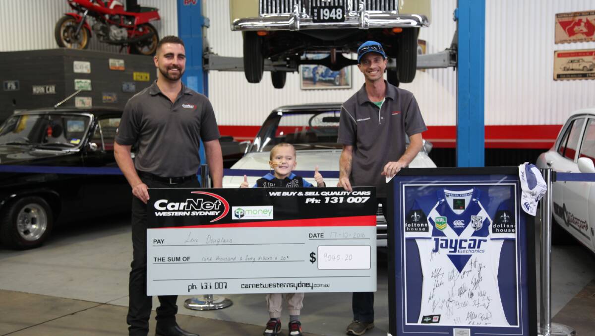Levi Douglass and his family accept their cheque at CarNet in McGraths Hill.