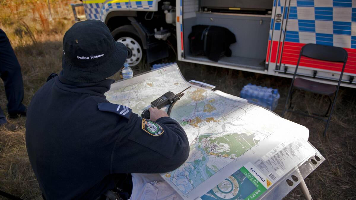 SEARCH: Police Rescue examine a map of bushland where Bindi Cheers was reported missing. Picture: Perry Duffin