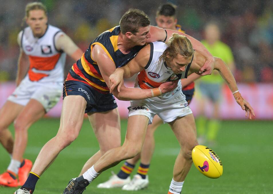 Adelaide Crows player Josh Jenkins tackles GWS Giants player Nick Haynes during the qualifying final on Thursday night. Picture: AAP