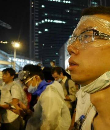 Protester wearing makeshift protection looks on as demonstrations continue. Photo: Philip Wen
