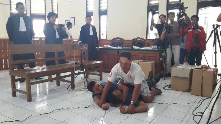 Pullman Hotel security guard Suryana (in blue shirt) plays Sara Connor in a reenactment at Denpasar District Court on Tuesday. Photo: Amilia Rosa