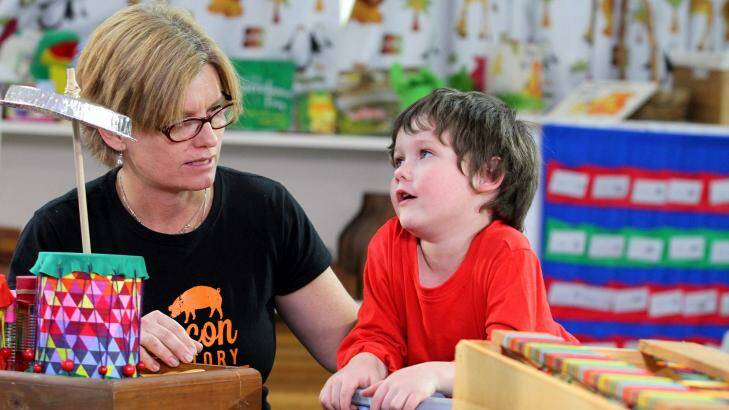 Isaac Delporte, 4, from Sandgate, with producer Helen Morrison, gets some tips on playing the drums in the recycled instrument band segment for Sesame Street. Photo: Michelle Smith