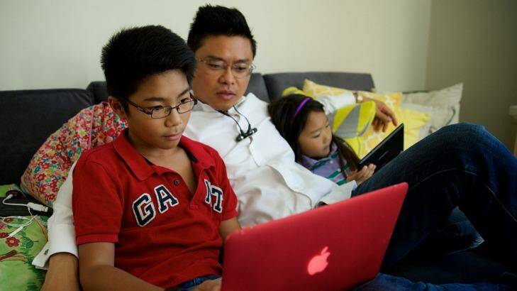Joss,12, and Darcy Nguyen, 7, often do school research online with their father Tung Nguyen on their tablet or laptop using the NBN. Photo: Wolter Peeters