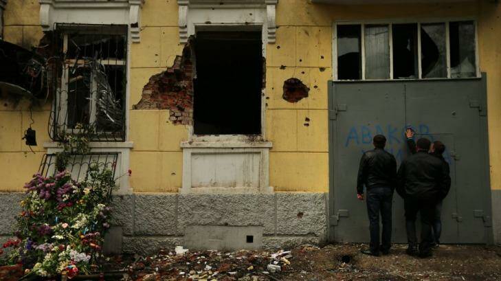 Attacked: Men inspect the ruins of the central police station  in Mariupol. Photo: Kate Geraghty