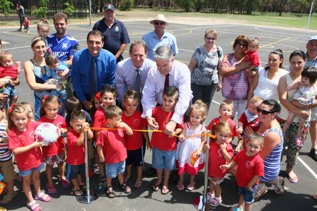 Let's play: Mario Pace (middle, from left), MP Bart Bassett and Penrith mayor Ross Fowler opened the new courts in Berkshire Park with Berkshire Park Day Care, the local RFS and other happy residents. Picture: Gary Warrick