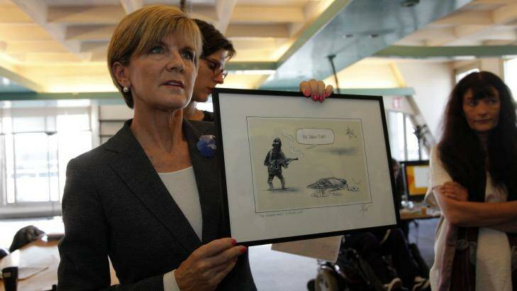 Julie Bishop shows off the cartoon before presenting it to the survivors of the Charlie Hebdo attack. Photo: Antoine Gyori