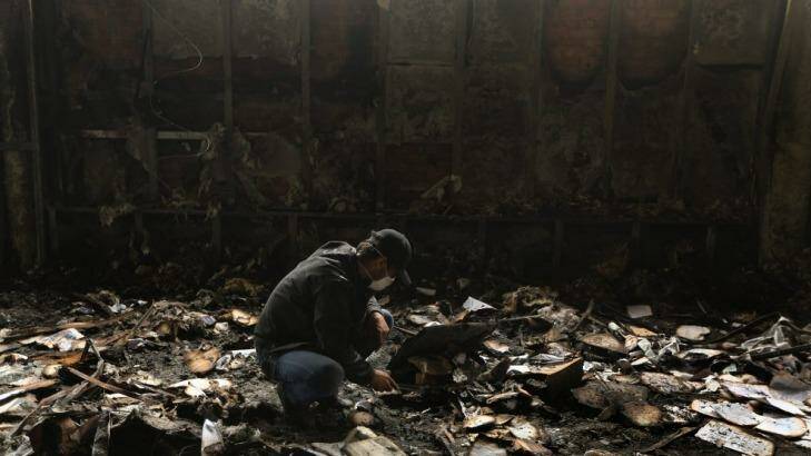 Sifting through debris: A man in a burnt-out bank in Mariupol. Photo: Kate Geraghty