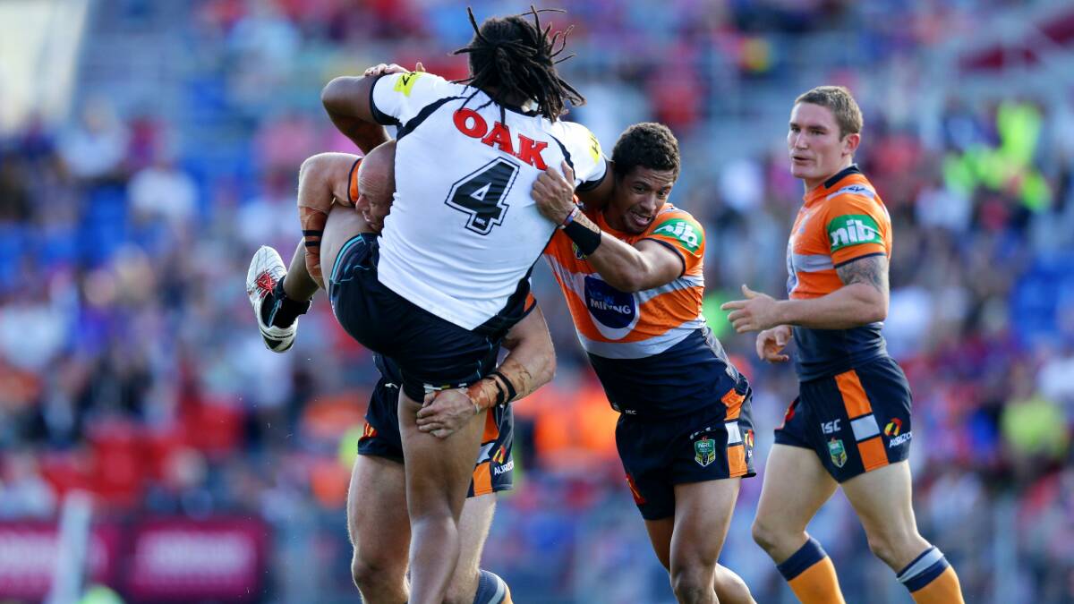 Tough Day: Jamal Idris runs into a wall of Knights defence in Newcastle on Saturday. Picture: Jonathan Carroll