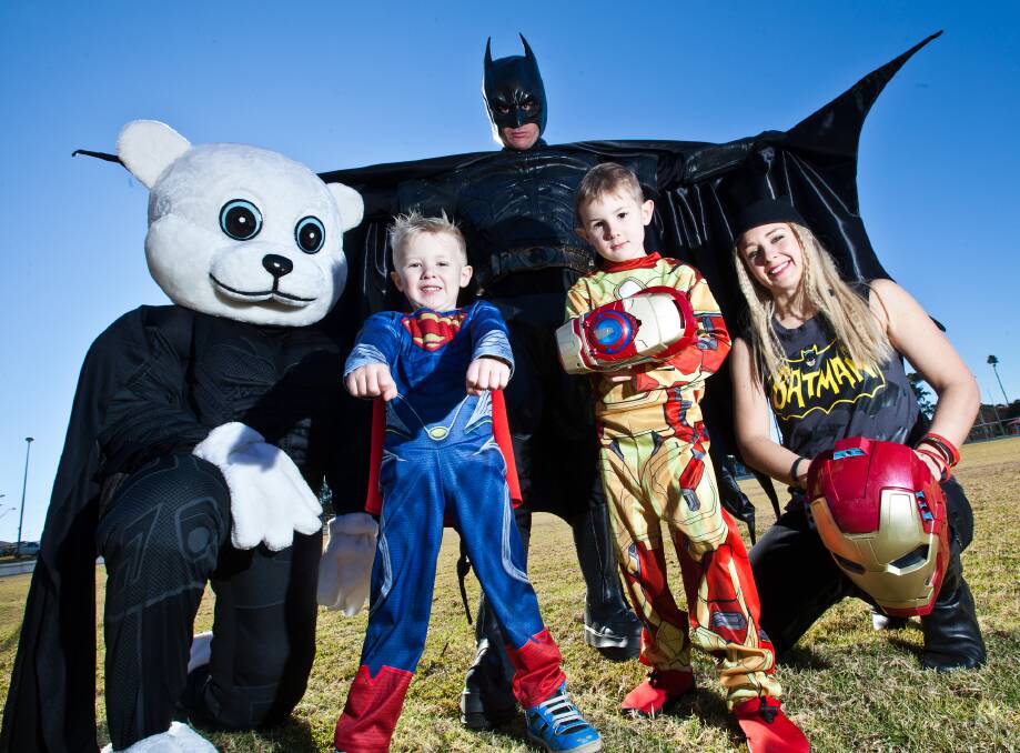 Bear Cottage’s Bandage Bear, with Batman (Tim Parmenter), Catwoman (Kym Parmenter), and their superhero sons Ashton, 4, and Dylan, 6.