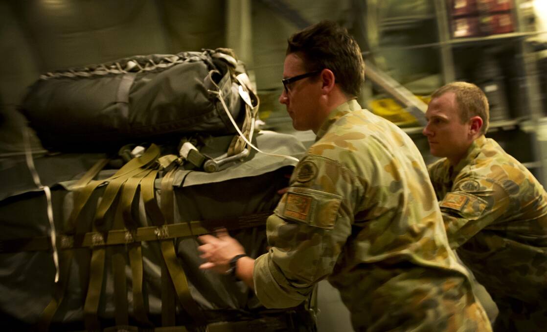 Personnel from 176 Air Dispatch Squadron load bundles of humanitarian aid into the Royal Australian Air Force C-130J Hercules transport aircraft.