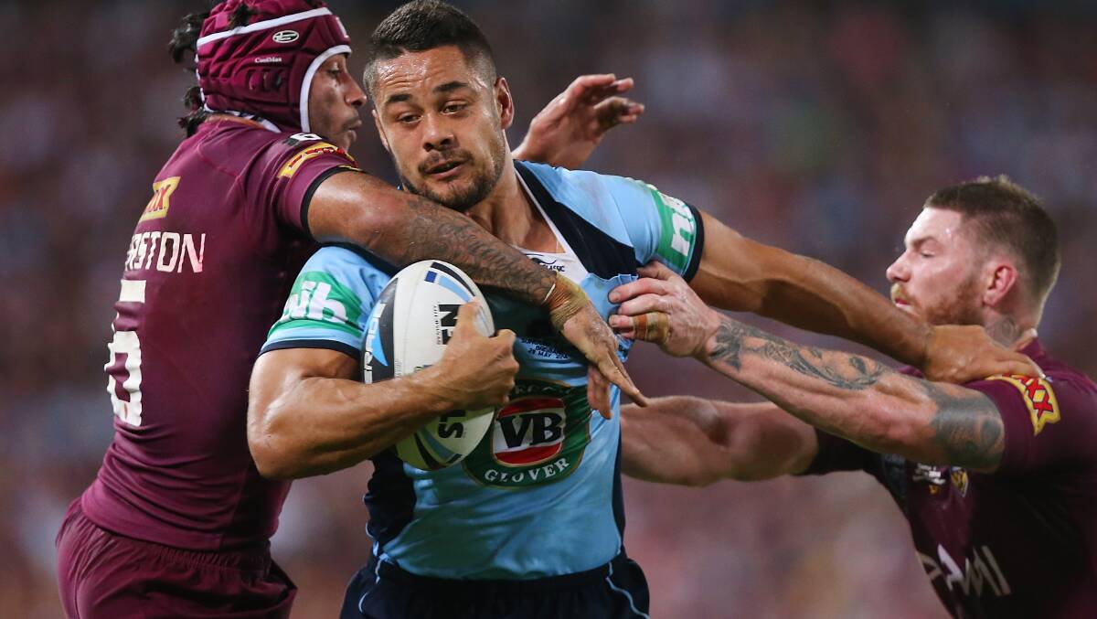 Jarryd Hayne of the Blues breaks through the defence of Johnathan Thurston and Chris McQueen of the Maroons to score a try during game one of the State of Origin series between the Queensland Maroons and the New South Wales Blues at Suncorp Stadium.