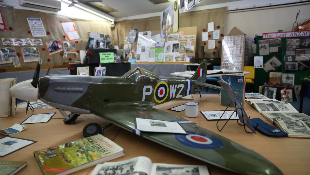 A large model spitfire and war history books occupy a table at the centre of Bligh Park Public School's Anzac display. Picture: Geoff Jones
