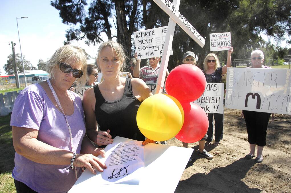 No Macca’s here: Kim Smith, left and Peta Levy join other local residents protesting at the designated site for a McDonald’s restaurant at South Windsor. Picture: Michael Szabath