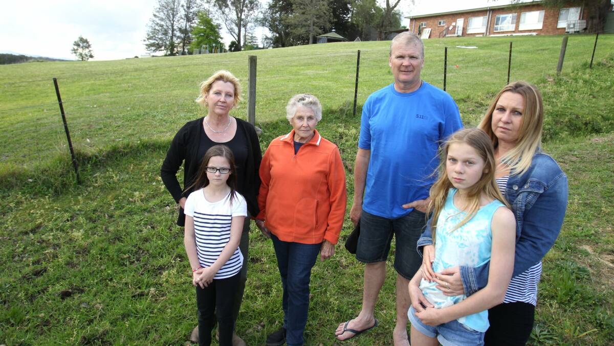 Keeping faith with Pitt Town’s character: Sandra Connor, her mother Pat Turner, their young neighbour, Makayla Atkins, and neighbours Greg Carroll and Kellie Cooper-Durant, with Kellie’s daughter, Sophie, near the proposed development site on St James’ Church’s land. Picture: Gene Ramirez