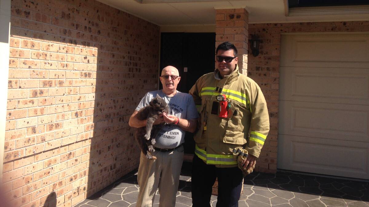 Richmond station captain James Rowland with the home owner and his cat.