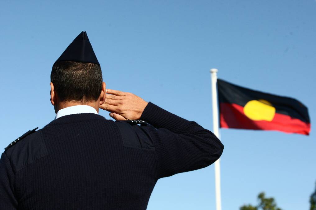 RESPECT: Senior Indigenous Liaison Officer Jonathan Lilley salutes the Aboriginal flag during the national annthem at the Reconciliation Week ceremony at Richmond RAAF base this morning. Pictures: Geoff Jones.