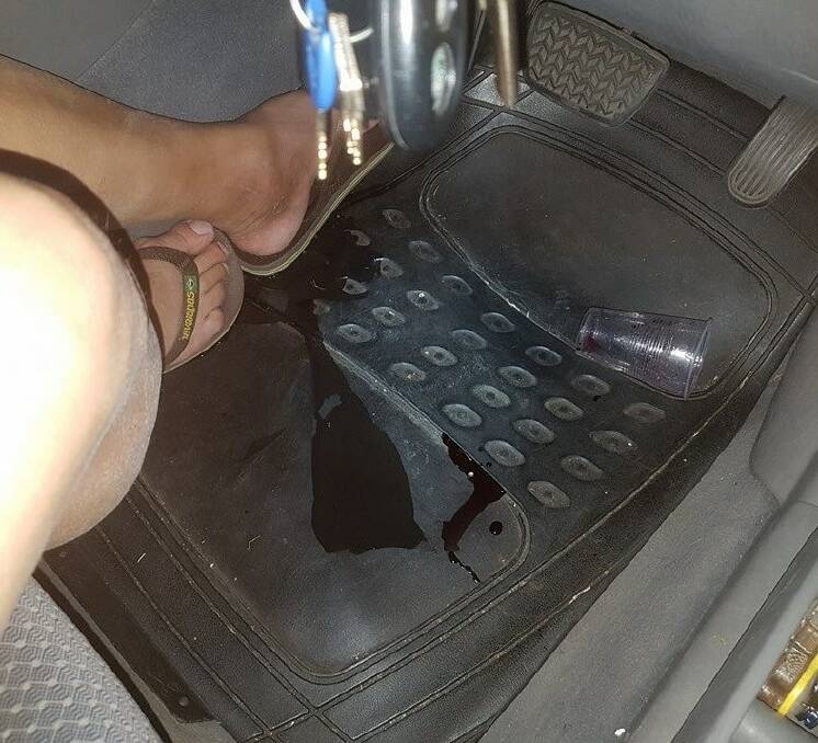 BUSTED: A man dumped his cup of red wine at his feet when he was pulled over for a breath test on Monday night. Picture: NSW Traffic and Highway Patrol Facebook.