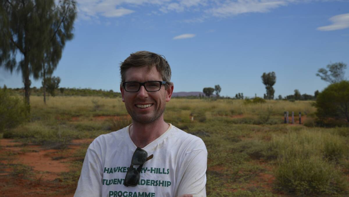 Dominic Perrottet, pictured with Uluru in the background, says the fact these students chose to do service work in the Northern Territory, as opposed to party during Schoolies said a lot about their character. Picture: Conor Hickey