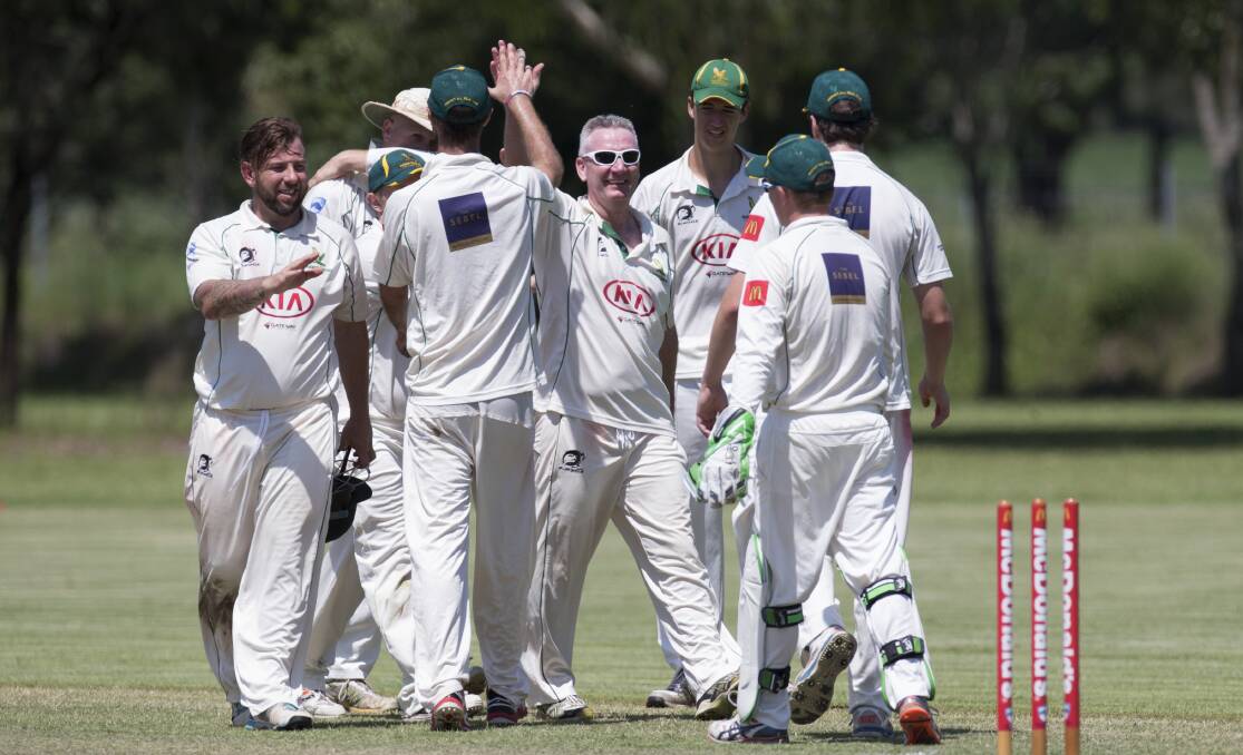 Steve Simons, centre, celebrates taking a wicket while playing for Hawkesbury's third grade side in February. Picture: Geoff Jones