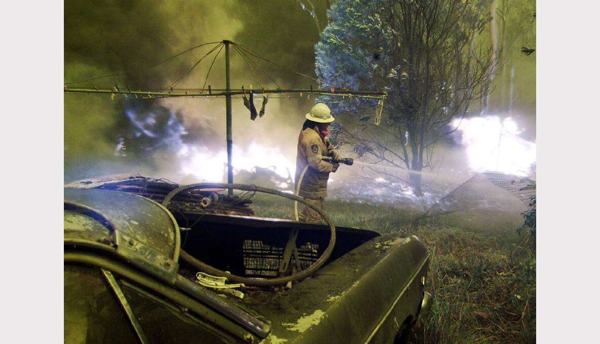 A firefighter battles to save a home near Warragamba during the 2001 fires. Photo: REUTERS