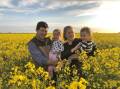 Ian and Amy Pursehouse with two of their three children, Charlotte and Henry, in a canola crop at Fairview.
