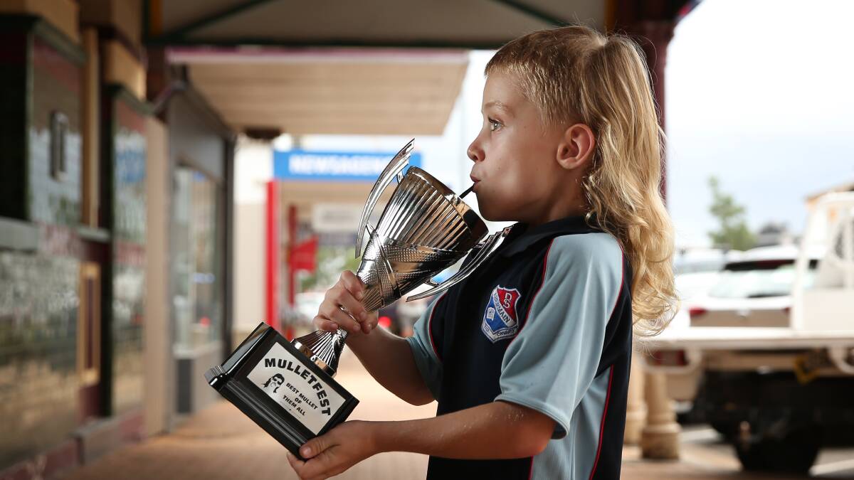 Max Johnson, 6, taking a sip from the the Best Mullet Of Them All trophy. Picture: Simone De Peak