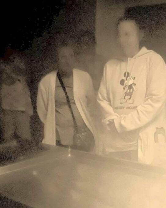 A photograph taken at Beechworth Asylum Ghost Tours on Saturday night, which director Geoff Brown says shows a semi-transparent figure standing behind two people. Picture by Manny Law.