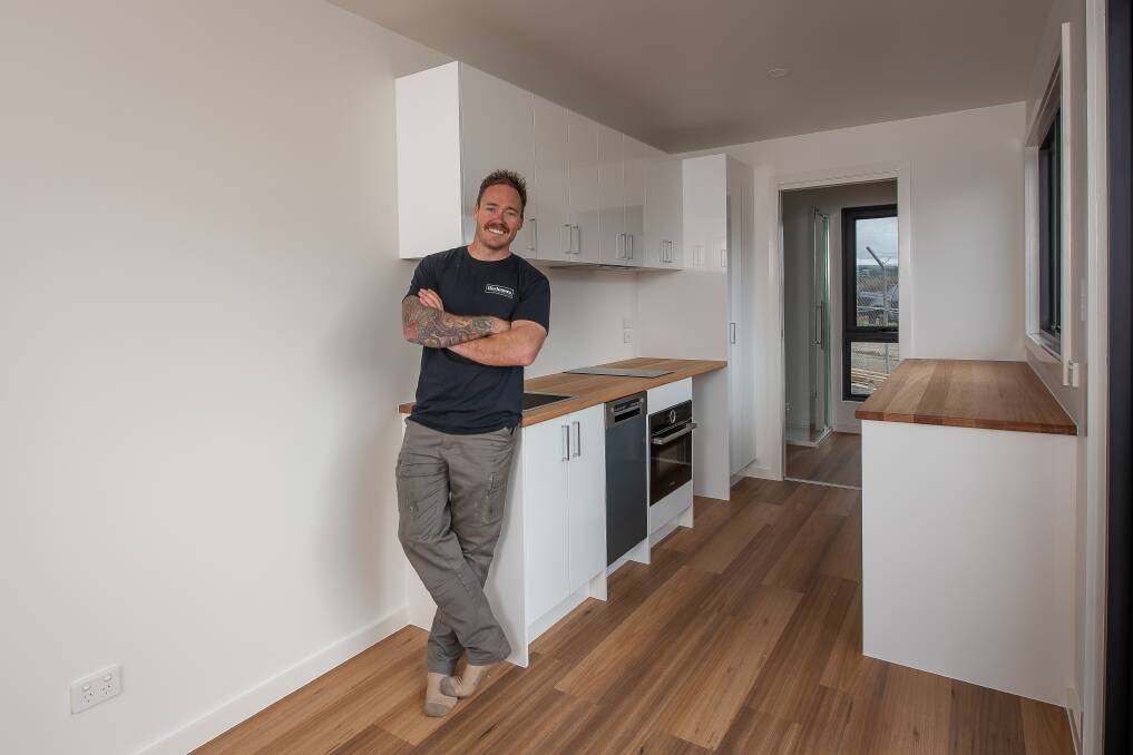 Jason Zadow in one of his tiny home models. Picture by Craig George. 