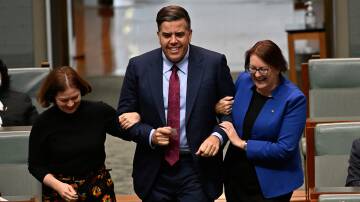 Nominated: Bendigo MP, Lisa Chesters (left), and Macquarie MP, Susan Templeman (right), drag the new Speaker, Oxley MP, Milton Dick, to the chair on July 26. Picture: Auspic.