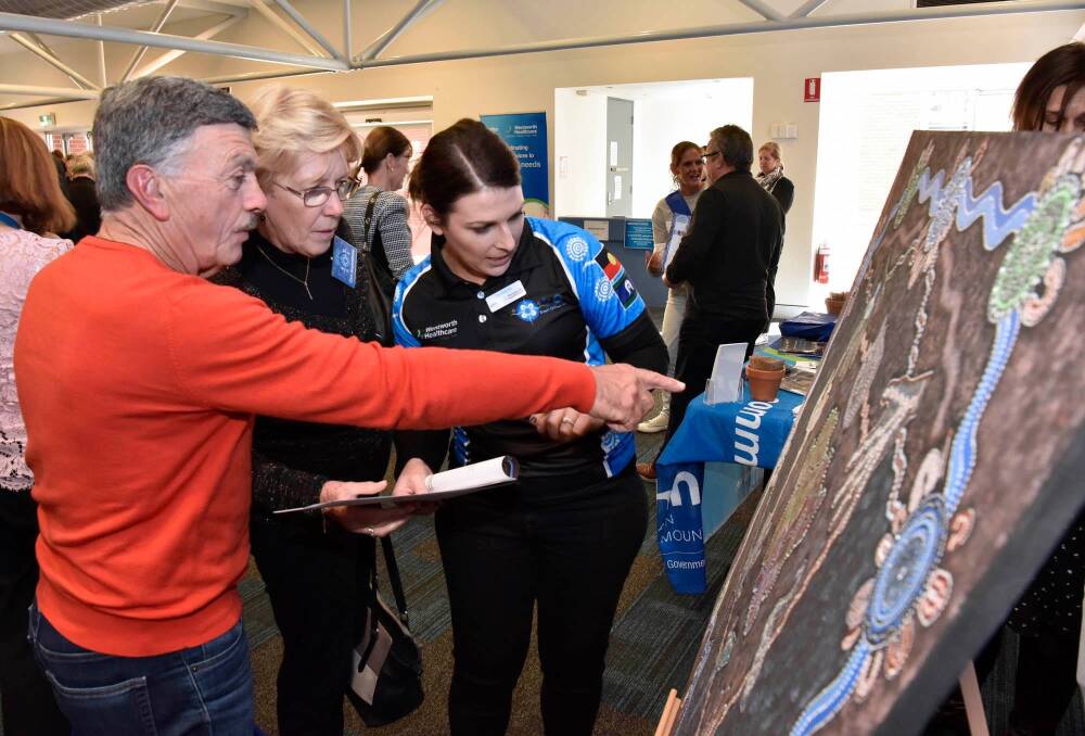 Attendees of the launch admire a piece of art by local aboriginal artist Vicki Thom, made for Wentworth Healthcare's Reconciliation Action Plan. Picture: Supplied