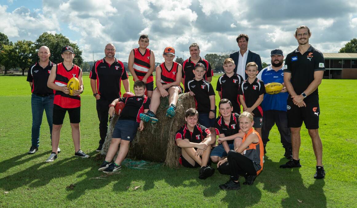 Recovery: AFL CEO Gillon McLachlan, GWS GIANTS player Phil Davis and members of the Hawkesbury Saints and Norwest Jets stand around a washed up hay bale at Bensons Lane. Picture: AFL