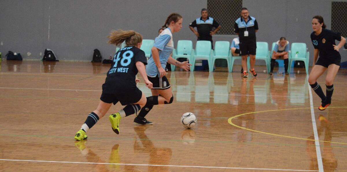 Getting there: Tia Berg (black) chases her opponent to steal the ball back for NSW City West at the National Futsal Championships held locally in January. Picture: Supplied