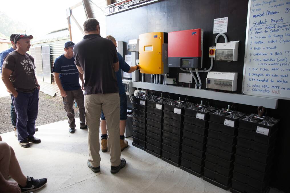Students inspect a battery system at the EarthCare Centre at WSU Richmond.