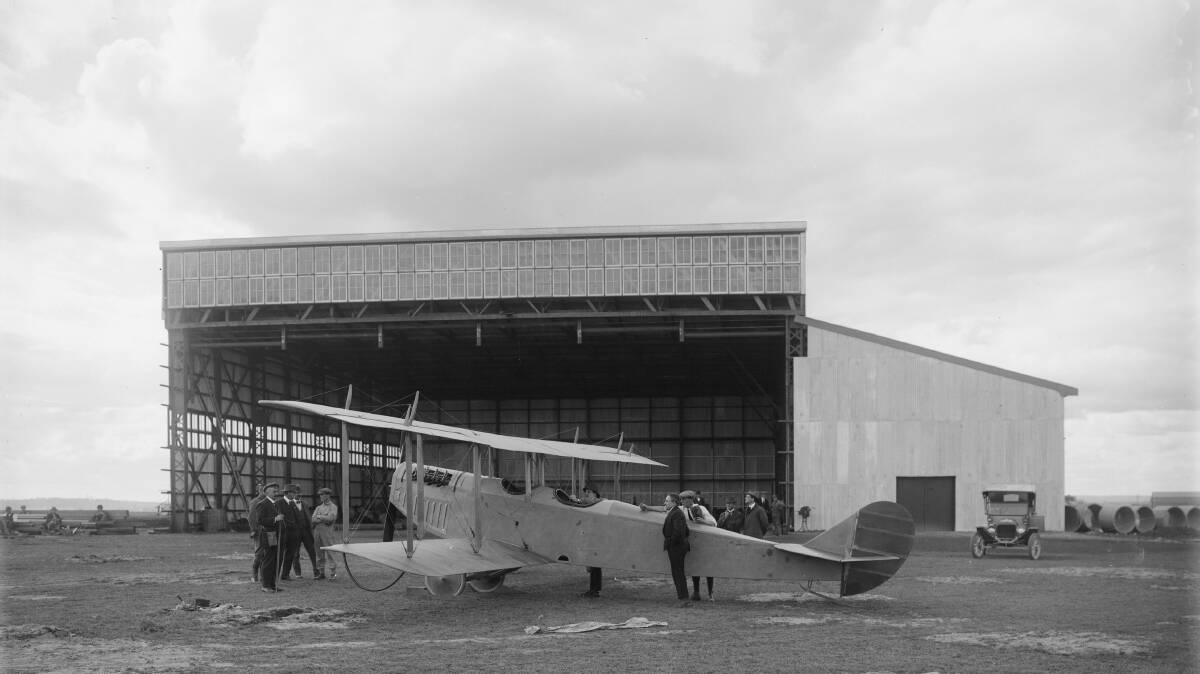 The NSW State Aviation School, July 21, 1916 on what is now the RAAF Base.  Timber for the western annexe of the hangar still lies stacked on the ground, as the first Curtis 'Jenny' trainer aircraft is checked out by Chief Instructor Billy Stutt (nearest camera) and the workers who had assembled and rigged the airframe.  Hurried patches in the aerodrome surface indicate the pace of preparations towards the official opening of the School on August 28, 1916. Picture: www.3squadron.org.au.  Charter Family Collection