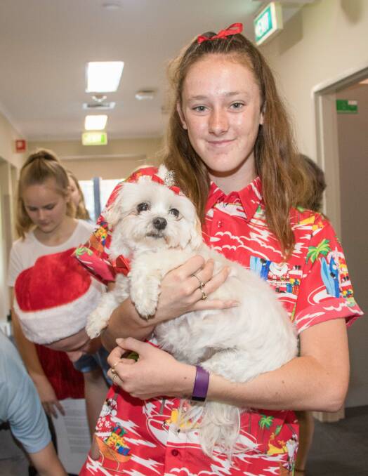 Choir student Erin Graham has an extra cuddle with Nepean therapy dog, Miley.
