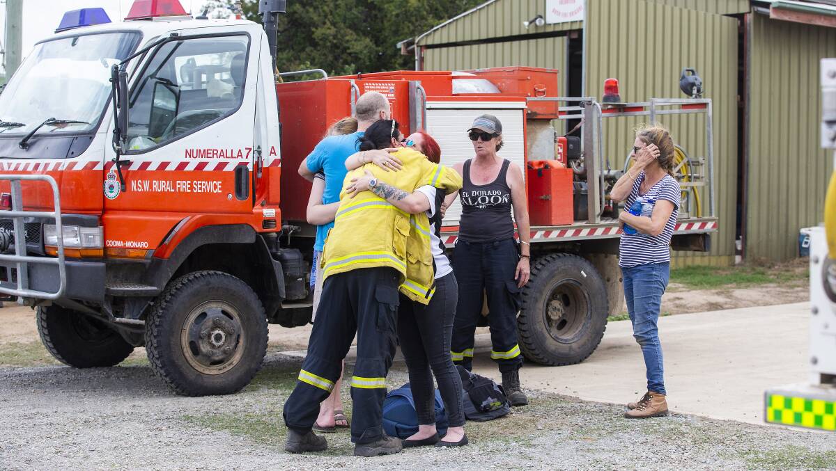 Firefighters embrace at Numeralla near the site of Thursday's air tanker crash. Picture: Getty Images
