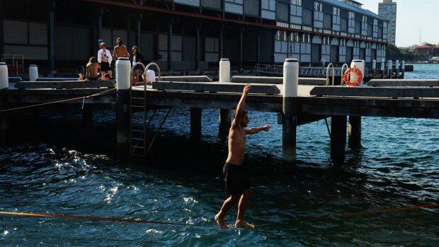Finding a way to cool off: Slackliners cross the harbour between Pier 1 and 2 in Dawes Point. Photo: Nick Moir