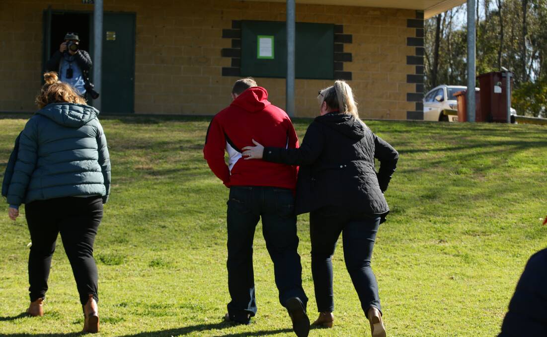 Members of The Singleton Roosters AFC Committee comfort each other on Monday. Picture by Simone De Peak