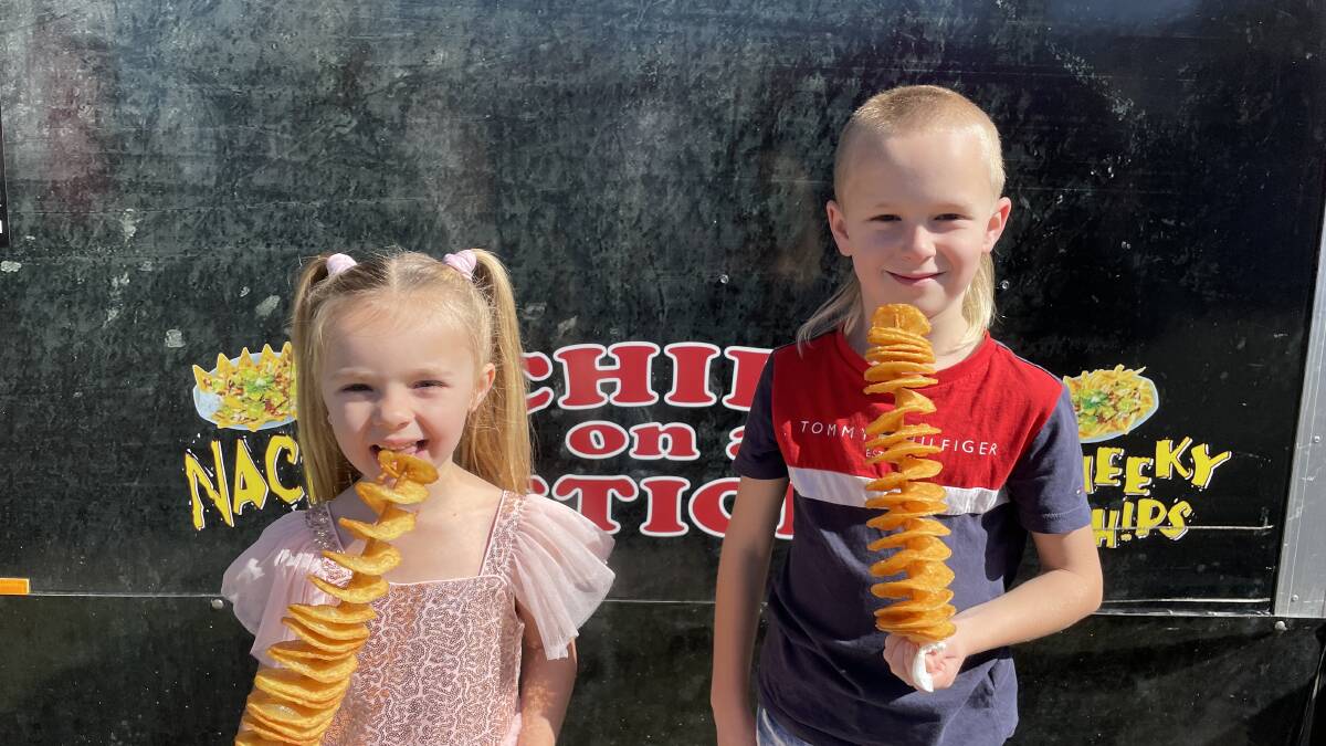 Lailah, 4, and Harley, 7, from Richmond, enjoy their Chips on a Stick. They were also looking forward to seeing the animals and going on the rides. Picture: Sarah Falson