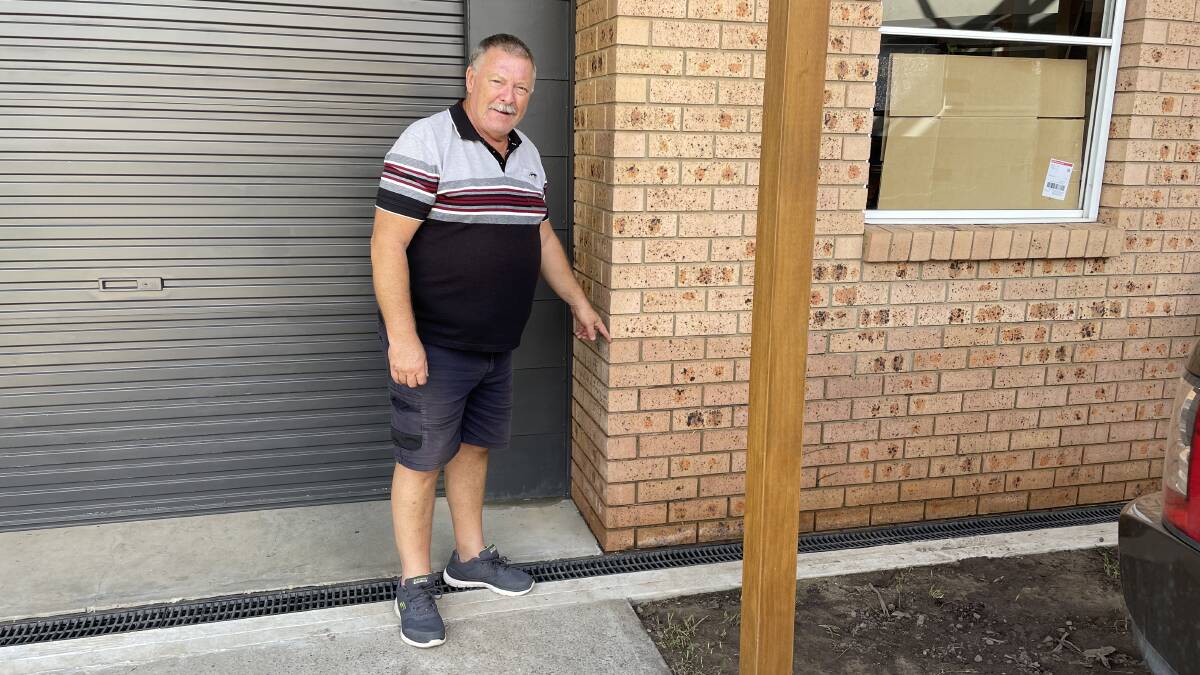 Steve Smith points to the area on the wall where the flood water peaked and covered the floor about a metre-and-a-half high in the bottom level of their Windsor house during the March 2022 flood. Picture: Sarah Falson 