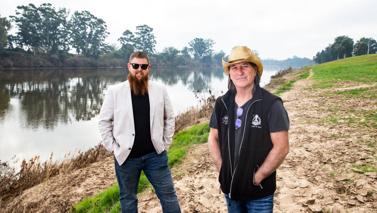 Scene of the devastation: Organisers of the Hawkesbury Flood Relief Concert, Jarryd Faint and Dave Wilkins, at Governor Phillip Park on the Hawkesbury River, Windsor, where the concert will be held on June 6. Picture: Geoff Jones